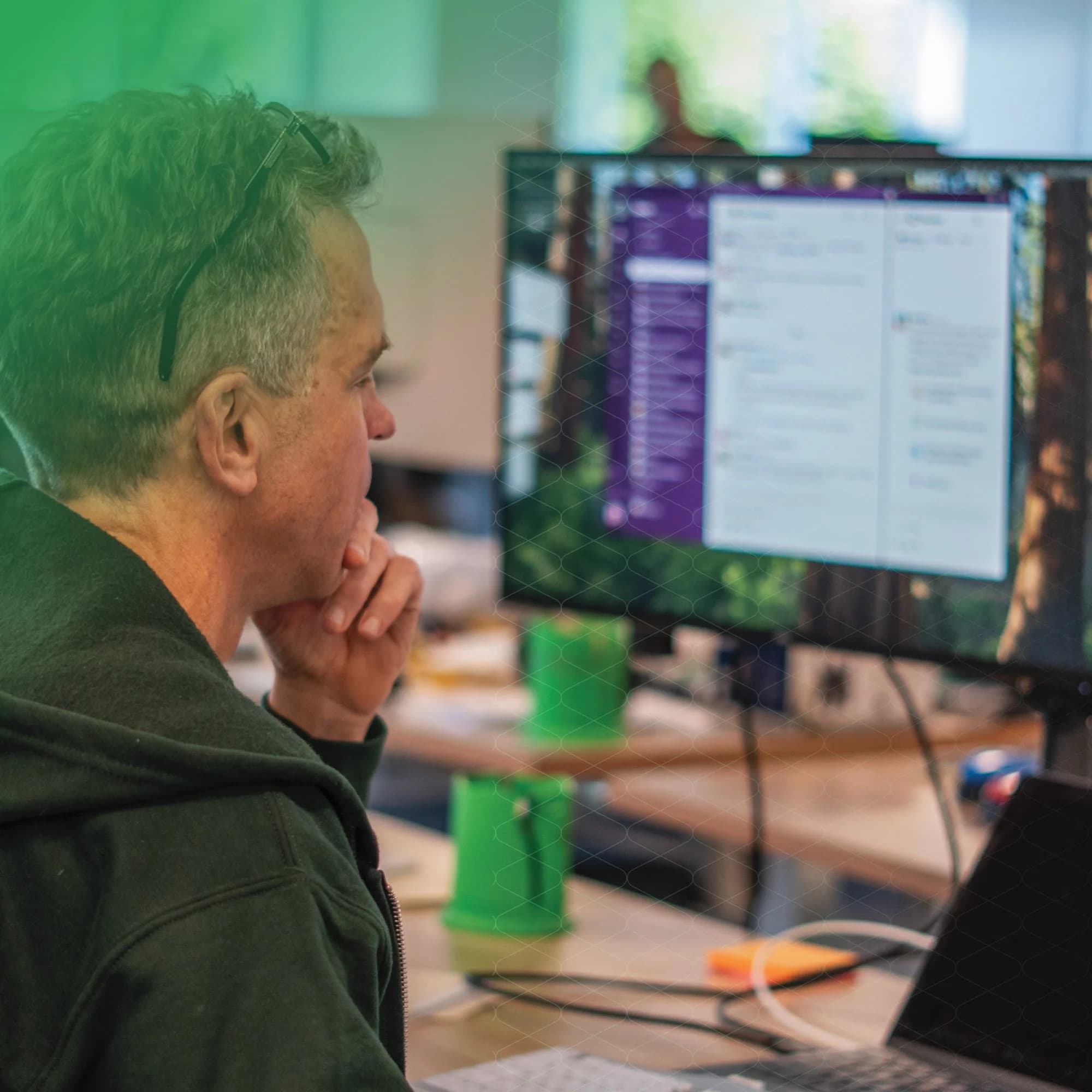 A person reviewing charts and data on a laptop in a modern workspace.